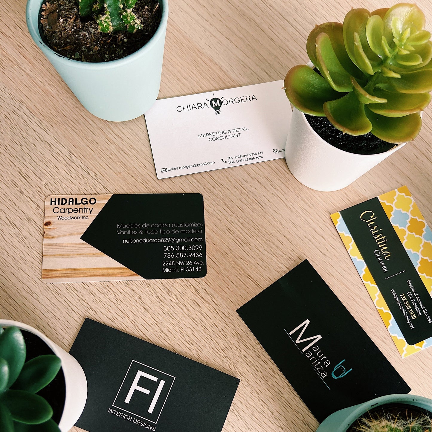 A set of business cards printed lay it out on top of a table in prntcards office.
