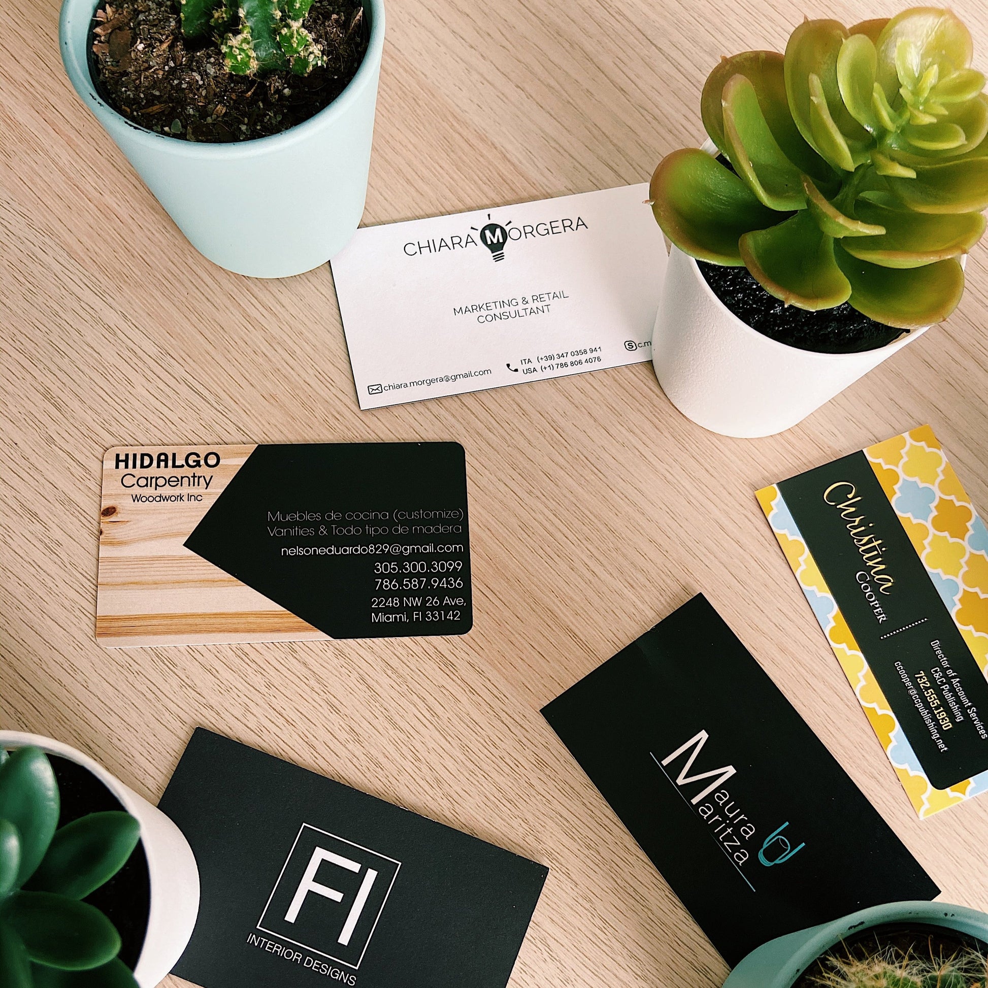 A set of business cards printed lay it out on top of a table in prntcards office.